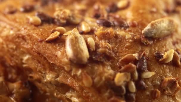 Imagens extremamente macro 4k de superfície rotativa de croissants doces ou bolos cobertos por sementes de girassol e gergelim — Vídeo de Stock