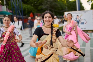 Stavropol, Rusya - 17 Mayıs 2019: Mutlu gülümseyen dindar krishna erkek ve kadın dua ve sokakta dans.