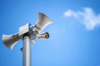Güvenlik fotoğraf makinesi ile hoparlörler ve megafon gökyüzü arka plan üzerinde
