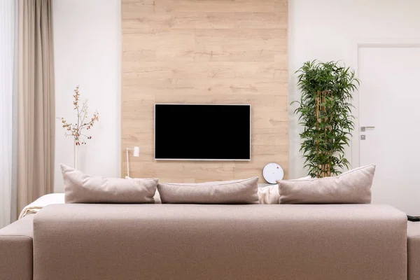 Ahşap duvar, vazo ve bitki kanepe ve yastık ve düz ekran lcd Tv ile modern minimalist lüks daire