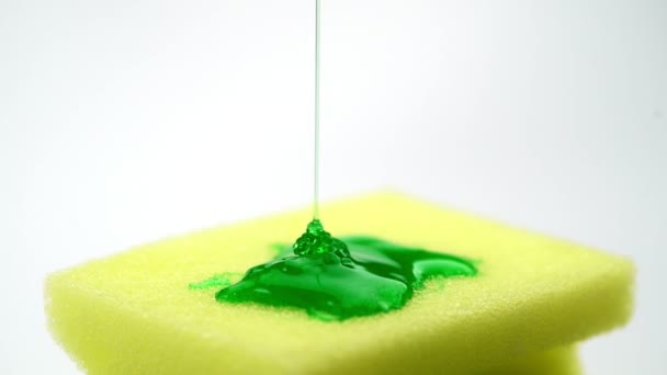 Super macro riprese ravvicinate di spugna gialla per piatto e detergente per versare sotto forma di gel verde. — Video Stock