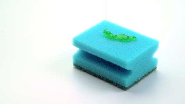 Super macro close up footage of blue sponge for dish and pouring detergent in form of green gel. — Stock Video