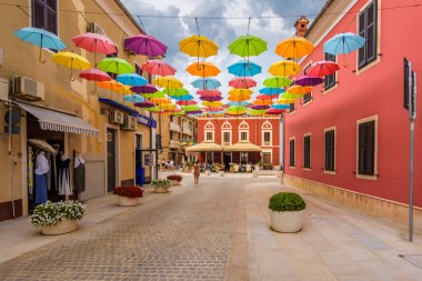 Novigrad, Croatia - August 17, 2025: Street view of Novigrad with colored umbrellas above the street