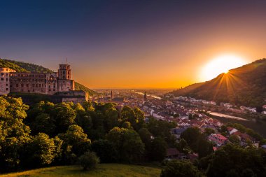 Almanya 'nın Heidelberg şehrinin panoramik günbatımı manzarası. Kale manzarası ve eski köprüyle Neckar nehri.