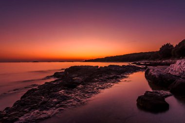 Hırvatistan plajında mor gökyüzü ile güzel bir gün batımı 