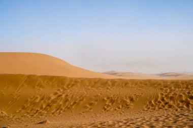 Dead Vlei rüzgar üfleme desenlerturuncu kumullar de Sossusvlei tepeleri arka planda tozlu tepelere solmaya.