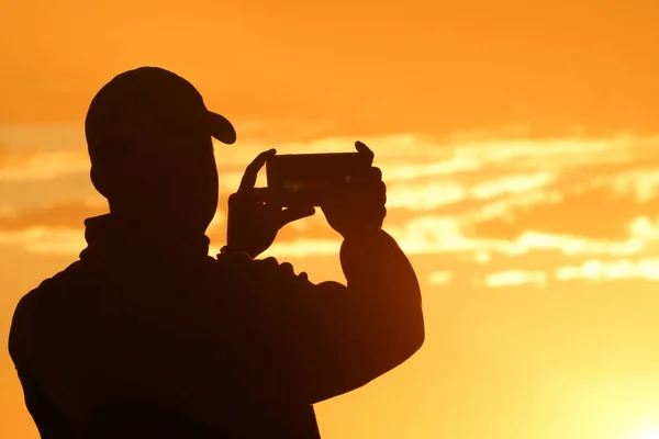 Silhouette Mann Von Untergehender Sonne Beleuchtet Foto Hält Ein Mobiles — Stockfoto