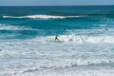 Coolangatta, Avustralya - July10 2018; Geniş surf beach beyaz dalga köpüğü derin turkuaz deniz yoluyla binmek sörfçü ile
