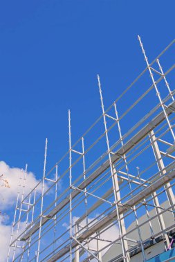 Steel construction scaffolding erected and rising into sky. clipart