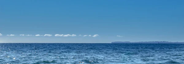 在遥远的地平线之上的稀薄的白云蓝天和海口气混合理想的用途作为背景图片 — 图库照片