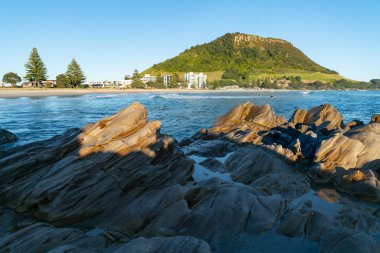 Landmark Mount Maunganui güneş gibi yükselir ve gölgeler ön plan taşa çevirir