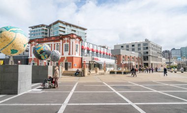 Wellington, Yeni Zelanda - 1 Ekim 2018; Adam karısıyla tekerlekli sandalye durdurmak Wellington waterfront turist acelesiz yürüyüş diğer dünyalar heykel ve Simgesel Yapı binalara bakmak için