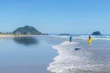 TAURANGA NEW ZEALAND - DECEMBER 18,2018; Long view beautiful ocean beach with people enjoying the weather and beach activities. clipart