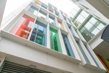 Çok renkli cam pencerelerile bina cephe. Modern mimari ve yapı, inşaat ve tasarım. Ticari mülkiyet veya gayrimenkul. Perspektif ve gelecek kavramı.