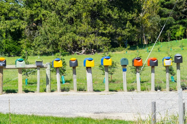 Двенадцать Почтовых Ящиков Конце Сельской Дороги Разных Цветов Столбах — стоковое фото