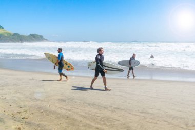 Mount Maunganui Yeni Zelanda - 10 Şubat 2019: Sörfçü yürümek ana plaj enteron bir kaba deniz gün için iyi bir yer arıyorum.