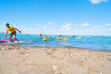 Mount Maunganui Yeni Zelanda - 10 Şubat 2019: su güven ve Mount Maunganui Surf kurtarma Kulübü tarafından becerileri geliştirme renkli kürek kurulları taşıyan çocuklar