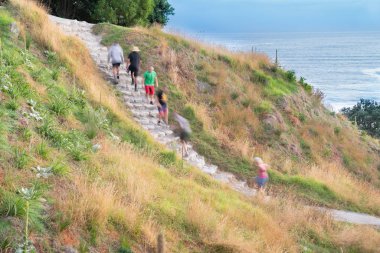 İnsanlar parça Mount Maunganui yukarı aşağı taş basamaklar üzerinde