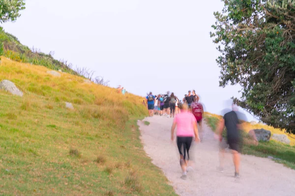 Imágenes borrosas de grandes grupos de personas caminando por la pista inclinada de — Foto de Stock