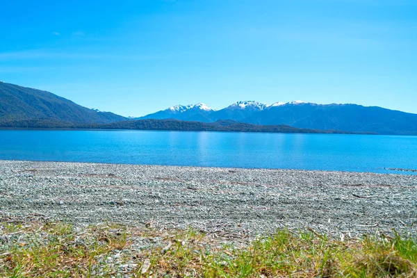 Lago Azul Te Anau e céu separados por montanhas cobertas de neve — Fotografia de Stock