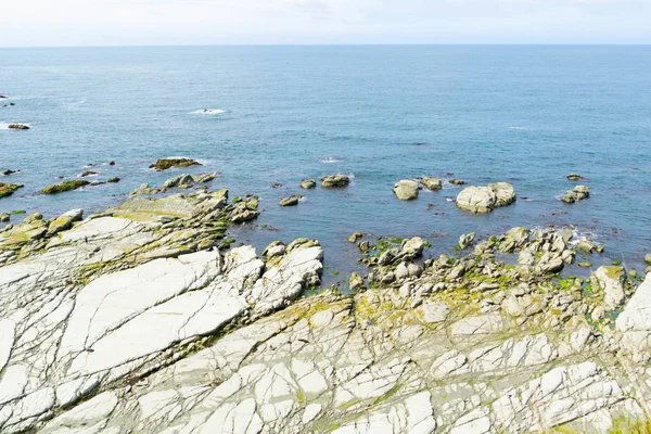 Bred platt lera-klippavsats sträcker sig ut i havet — Stockfoto