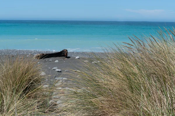 Praia pedregosa com mar e céu azul além como fundo panorâmico im — Fotografia de Stock