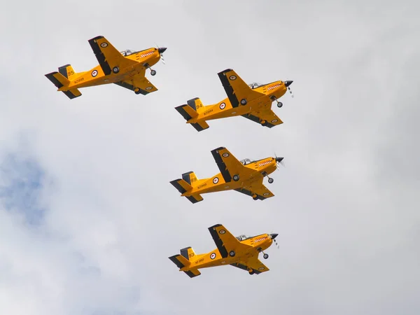 Négy sárga kiképző repülőgép flypast a formációban. — Stock Fotó