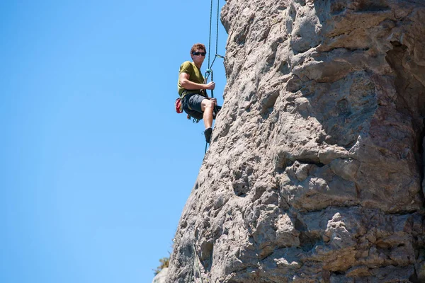 Genç maceracı kişi kaya tırmanışı — Stok fotoğraf