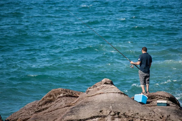 Man rock pesca aloneon base do Monte Maunganui . — Fotografia de Stock