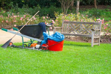 Gardener's equipment left on lawn clipart