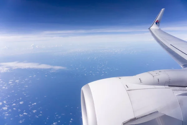 Boven de kunnen en de zee in Maleisische luchtvaartmaatschappijen vliegtuig. — Stockfoto