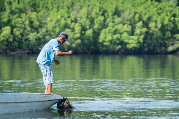 Рыбак в маленькой лодке и голубой рубашке — стоковое фото