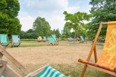 Çoğunlukla boş katlanır şezlong lar pub tarafından kullanılmak üzere şehir parkında dışarı