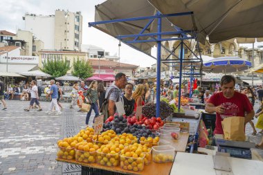 Sokak meyve satıcısı Plaka 'da müşteriler için bir torba meyve tartıyor 