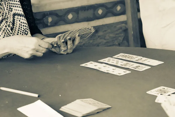 Sepia toned aged image effect  of hand holding the cards playing