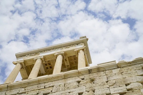 Structure supported by four pillars atop stone wall — Stock Photo, Image