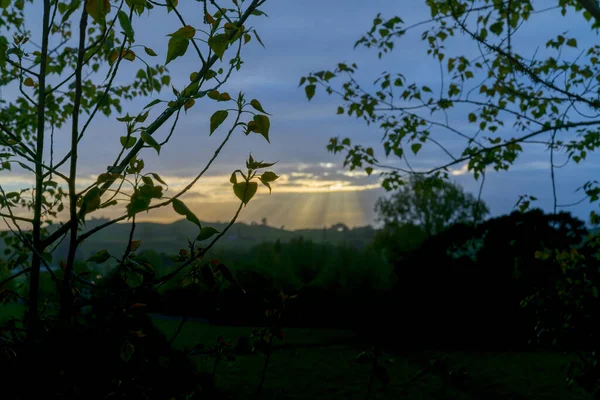 雲の隙間から昇る太陽が風景を照らす — ストック写真