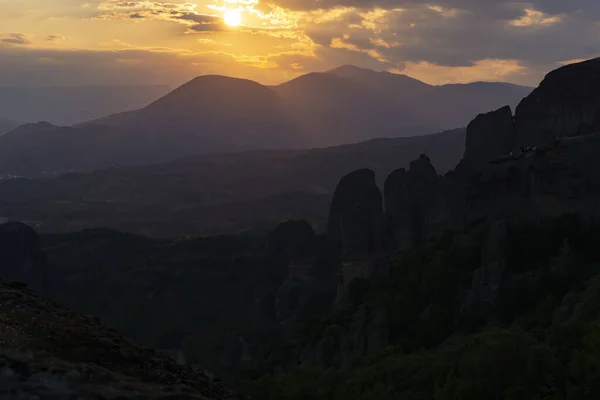 Coucher de soleil derrière des nuages spectaculaires et au-delà de la silhouette sombre mo — Photo