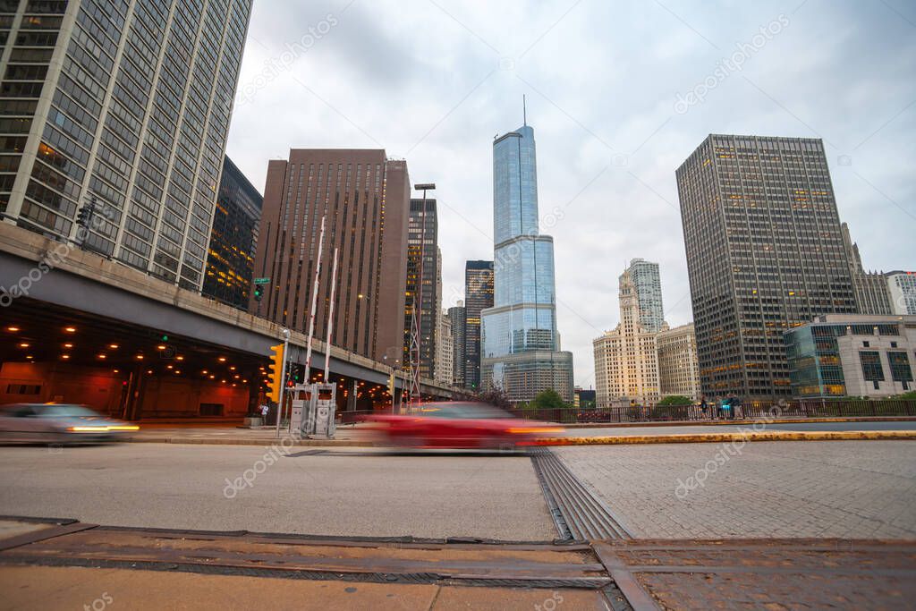 Chicago USA-  August 27 2015; 1Cars blurred passing in  street scene, intersection East Upper Whacker and Columbus Drive tiered road and highrise buildings, Chicago, Illinois, USA