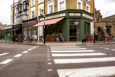 Londra İngiltere - 20 Ağustos 2015; yaya geçidi caddede şarküteri bulunan geleneksel banliyö binasına giden yolu gösteriyor.