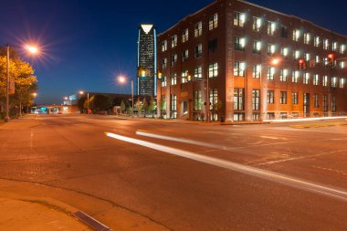 Oklahoma City USA - 8 Eylül 2015; Bricktown miras binaları gece modern Devon Enerji Merkezi ile uzak mesafe, Route 66