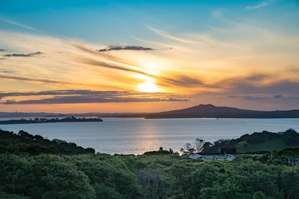 Waiheke Adası 'ndan Rangitoto Adası, Auckland Yeni Zelanda' ya gün batımı manzarası.
