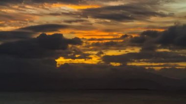 Günbatımı Deniz Zaman atlaması. Güneş, Filipinler 'deki Palawan Adası' ndaki Puerto Princesa yakınlarında hızla hareket eden bulutların ardında batıyor..