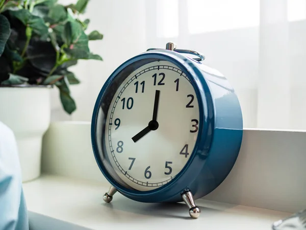 Clock at eight o\'clock on clock face at top of bed close up