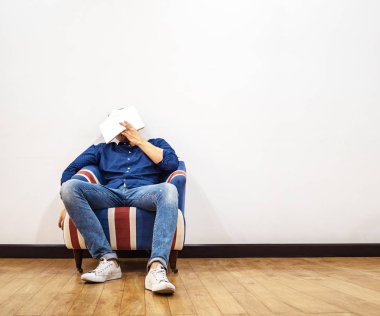 Adam yüzünde kitap okumak ve odaya uykuya