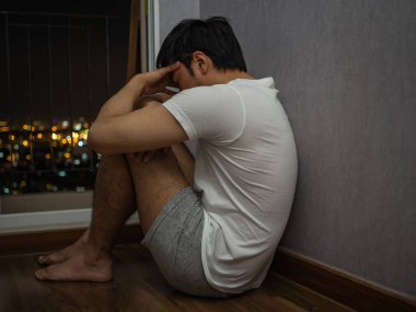 Pencerenin önünde oturan, diz sarılma ve ağlayan adam