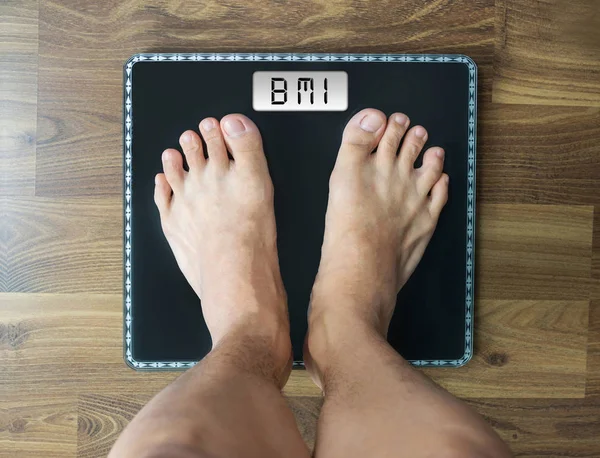 BMI text on digital weighing scale, person's looking down view