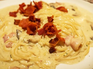 Spagetti Carbonara üstüne gevrek duman pastırma ile yakın