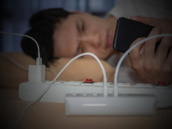 Человек Помощью Телефона Лежа Кровати Электрическими Проводами Зарядки Телефона — стоковое фото