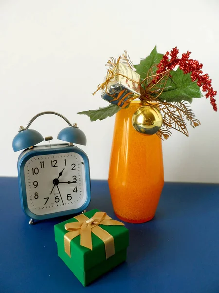 Noel kompozisyonu. Çalar saat, beyaz arka planda hediye kutusu. Noel konsepti.